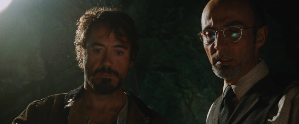 Tony Stark and Ho Yinsen in the original Iron Man. Tony is about to create his salvation after the does of inspiration from Yinsen.